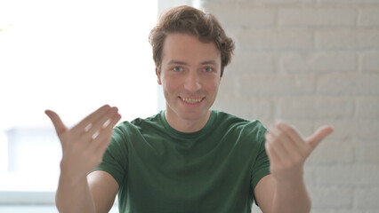 Inviting Young Man Pointing at the Camera