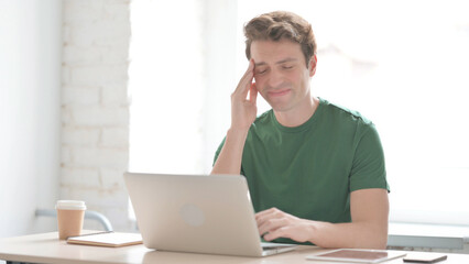 Young Man with Headache Working on Laptop
