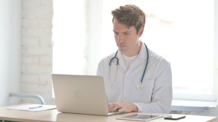 Young Doctor Working on Laptop in Clinic