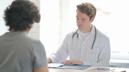Young Doctor Talking with Patient in Clinic, Treatment