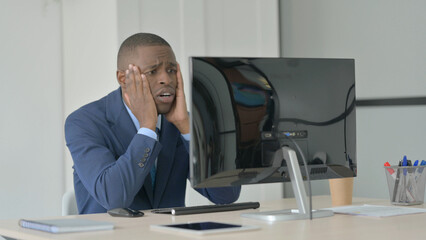 Fototapeta premium Young African Businessman Reacting to Loss While Working on Computer