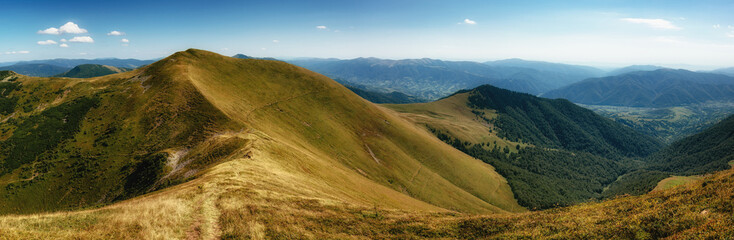 Amazing panoramic mountains valleys landscape in summer. View of light and afternoon shadow over scenic  hills, clear blue sky.