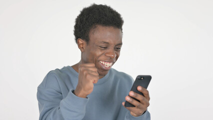 Young African Man Celebrating Success on Smartphone on White Background