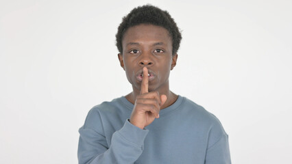 Fototapeta na wymiar Young African Man with Finger on Lips, Silence on White Background