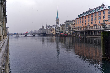 Fototapeta premium Beautiful cityscape of the old town of Zürich with protestant church Women's Minster, Minster Bridge and Limmat River in the foreground. Photo taken December 16th, 2022, Zurich, Switzerland.