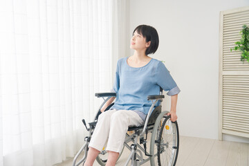 Fototapeta na wymiar 家で車椅子に乗る障がい者女性