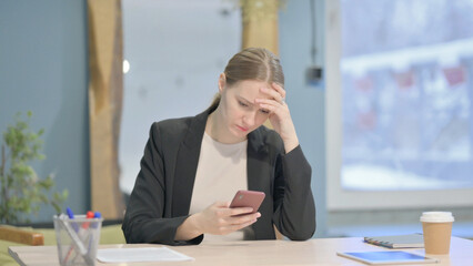 Upset Businesswoman Reacting to Loss on Smartphone