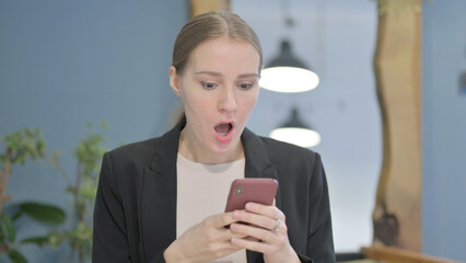 Shocked Businesswoman Reacting to Loss on Smartphone