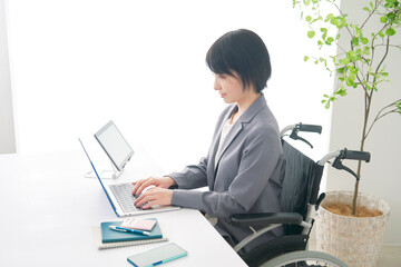 オフィスで車椅子に乗って働く障害者のビジネスウーマン