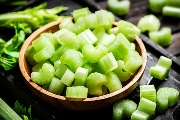 Sliced fresh celery. On a dark wooden background.