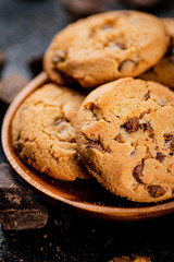 Wooden plate with cookies and pieces of milk chocolate. 