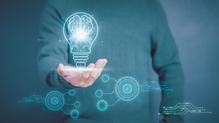 Man holding a glowing abstract light bulb on a wooden table, business problem solving ideas and...