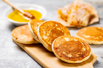 Pancakes on a cutting board with honey. 