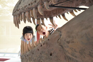恐竜の化石おくからびっくりしている兄妹