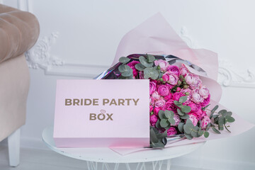 Bride's box for a bachelorette party on the background of a bouquet of flowers.

