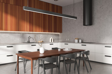 Stylish kitchen interior with seats and eating table on grey concrete floor