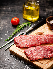 Raw steak on a wooden cutting board. 
