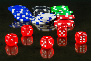 On mirror surface are casino chips and dices for playing poker