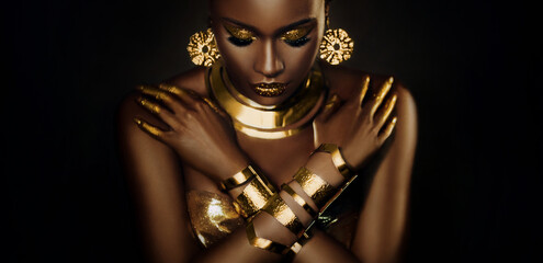 Art portrait african woman fashion model on black background, gold luxury accessories bijouterie...