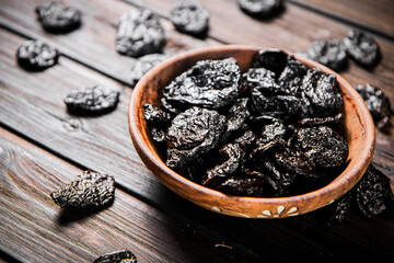 Prunes wooden plate on the table. 