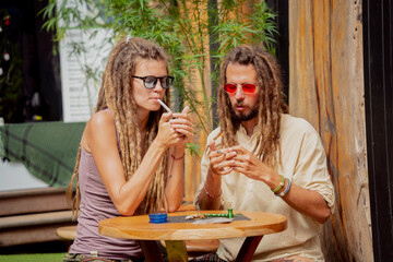 Hippie style couple smoking cigarettes with medical marijuana