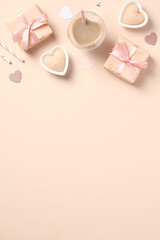 Happy Valentines Day vertical banner design. Flat lay composition with gift boxes, heart-shaped coffee cup, candles on pastel beige background.