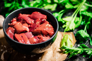 Raw liver in a bowl with parsley. 