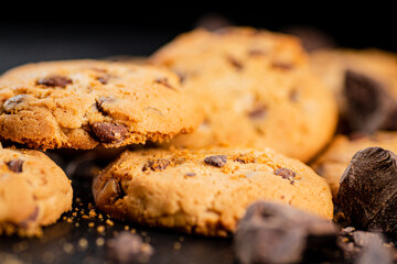 Cookies with pieces of milk chocolate on a stone board. 