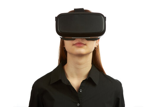 Young teen girl in a virtual reality helmet isolated on a blue background plays a 3d computer game.