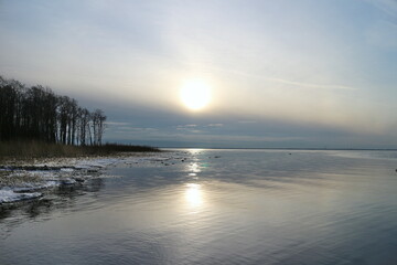 cold winter sun hangs low over the horizon, seascape