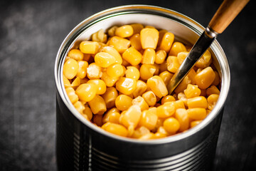 Canned corn in a tin can with a spoon. 