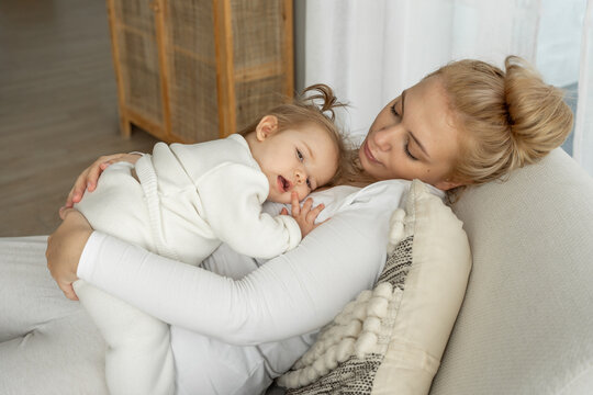 Mom Makes Baby Toddler Sleep, Lull, Kid Sucks Pacifier. Parent And Child Lie On Couch. Maternity Parent Daily Routine