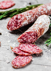 Pieces of salami sausage with sprigs of rosemary. 
