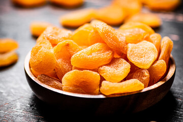 Full wooden plate with dried apricots. 