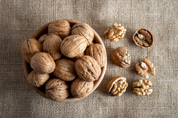 Peeled walnuts and whole walnuts on burlap sack
