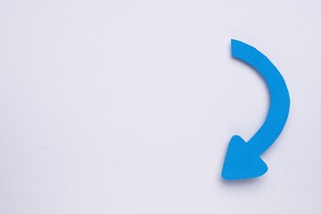 Paper curved arrow on white background, top view. Space for text