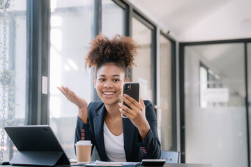 Young working woman video chatting on smartphone.