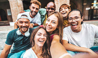 Multicultural friends taking selfie picture with smart mobile phone device outdoors - Group of...