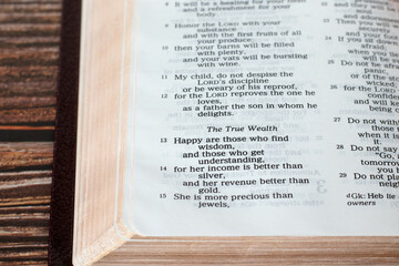 Bible verse about true wealth (wisdom) in Proverbs book. A closeup. Christian biblical concept.