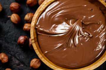 Hazelnut butter with peeled hazelnuts on the table. 