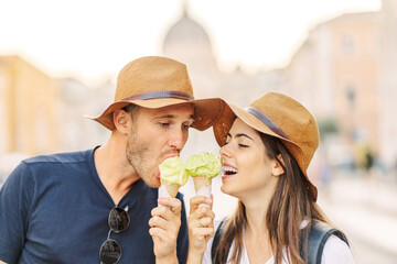 Happy couple eating ice cream in Rome, Italy. Beautiful bright ice cream with different flavors in...