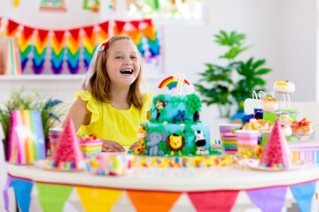 Child birthday party. Kids blow candle on cake.