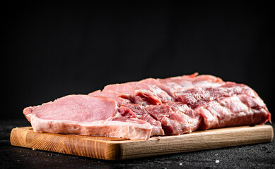 Raw pork sliced on a wooden cutting board. 