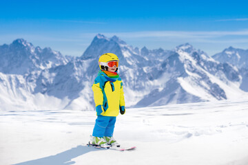 Fototapeta na wymiar Ski and snow fun for child in winter mountains