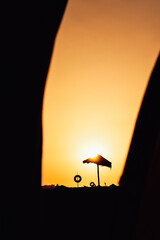 Silhouette of an umbrella on the beach at sunset. Algarve, Portugal. 