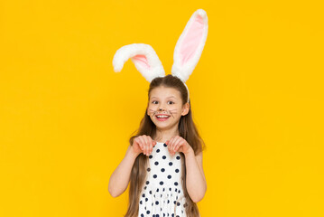 Portrait of a beautiful girl with big ears of an Easter bunny on her head, the onset of the Easter...