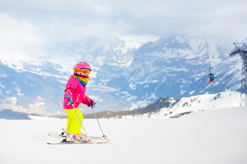 Ski and snow fun. Child in winter mountains.