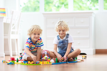 Kids play wooden railway. Child with toy train.