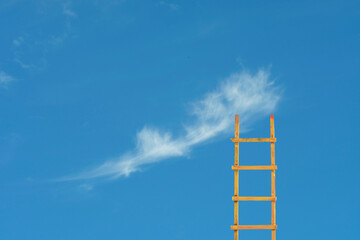 Business vision development,start up and ideas concept. Ladder of success leading to a cloud in the blue sky.Large copy space