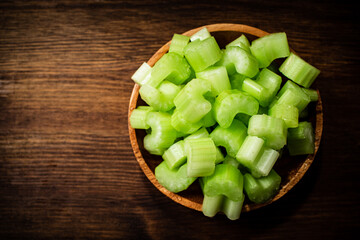 A wooden plate with a piece of celery. 